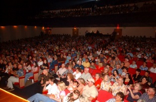 Large audience seated inside the theatre