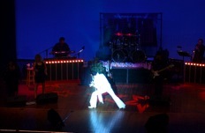 Performer highlighted by a stage spotlight
